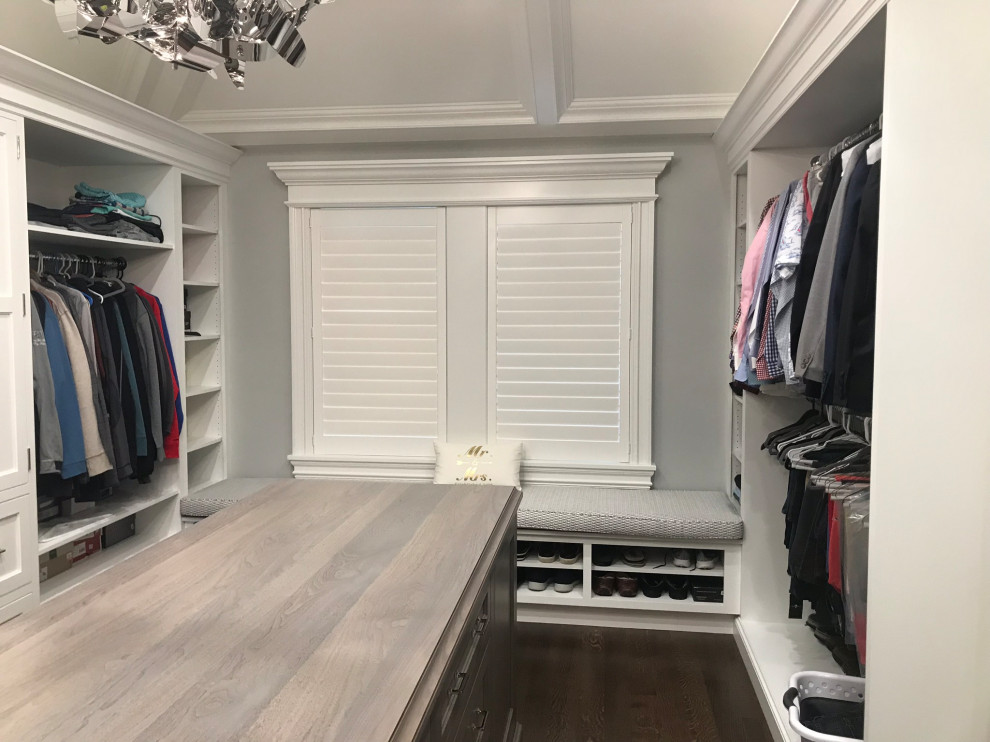 Ejemplo de armario vestidor clásico grande con armarios con paneles empotrados, puertas de armario de madera en tonos medios, suelo de madera oscura, suelo marrón y casetón