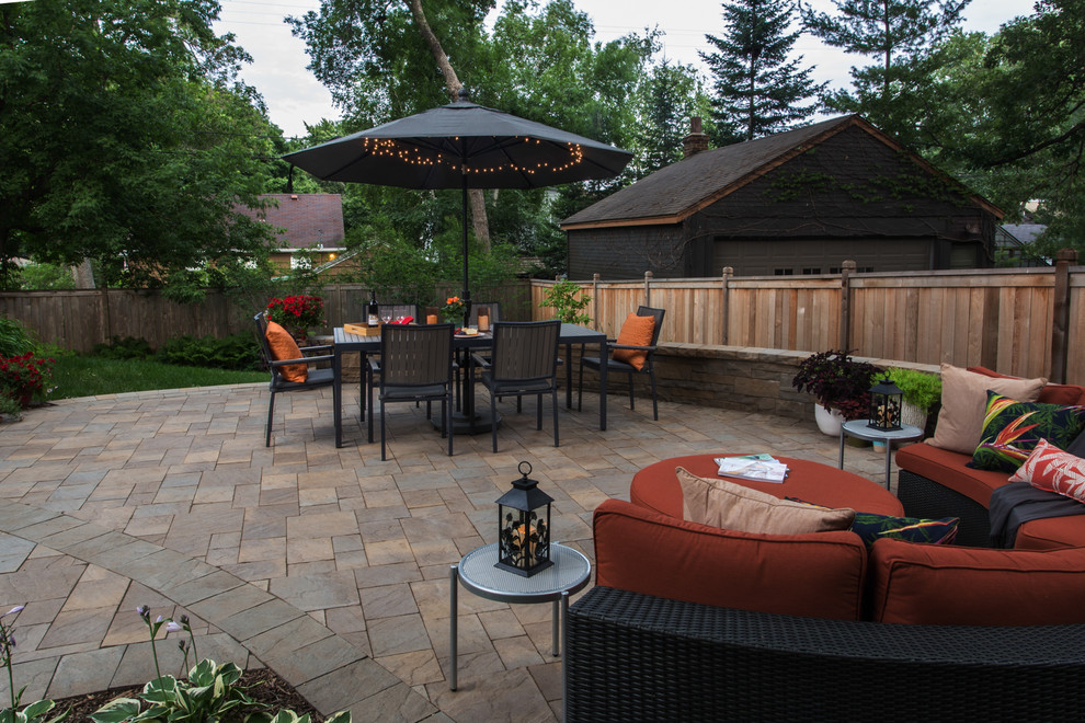 This is an example of a small contemporary backyard patio in Minneapolis with brick pavers.
