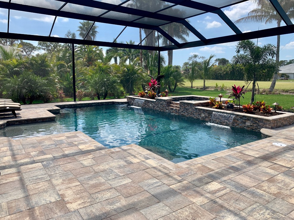Photo of a mid-sized pool in Miami with natural stone pavers.