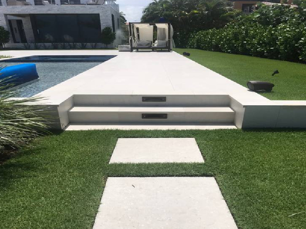 Photo of a mid-sized modern custom-shaped pool in Miami with tile.