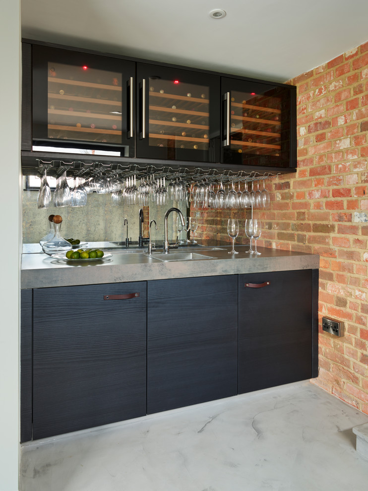 Photo of a contemporary single-wall wet bar in Berkshire with a drop-in sink, flat-panel cabinets, blue cabinets, mirror splashback, grey floor and grey benchtop.