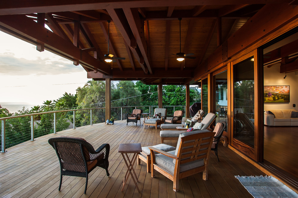 Design ideas for a large tropical deck in Hawaii with a roof extension and cable railing.