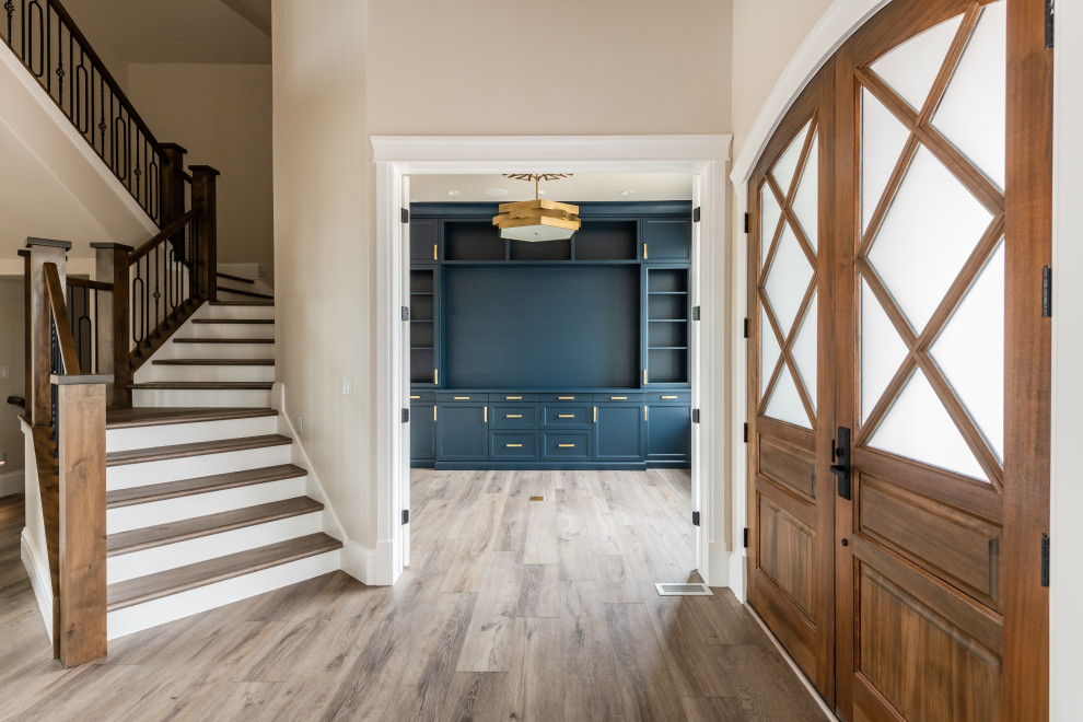 Inspiration for a mid-sized transitional foyer in Salt Lake City with beige walls, vinyl floors, a double front door, a medium wood front door and brown floor.