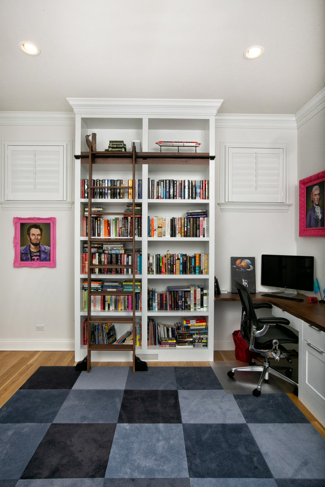 Design ideas for a mid-sized traditional home office in Chicago with a library, white walls, light hardwood floors, a built-in desk and yellow floor.