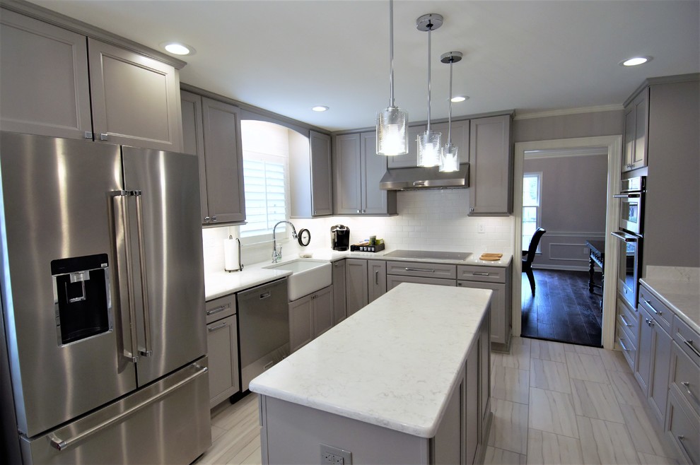 Example of a large transitional u-shaped porcelain tile and beige floor eat-in kitchen design with a farmhouse sink, recessed-panel cabinets, gray cabinets, granite countertops, white backsplash, subway tile backsplash, stainless steel appliances, an island and beige countertops