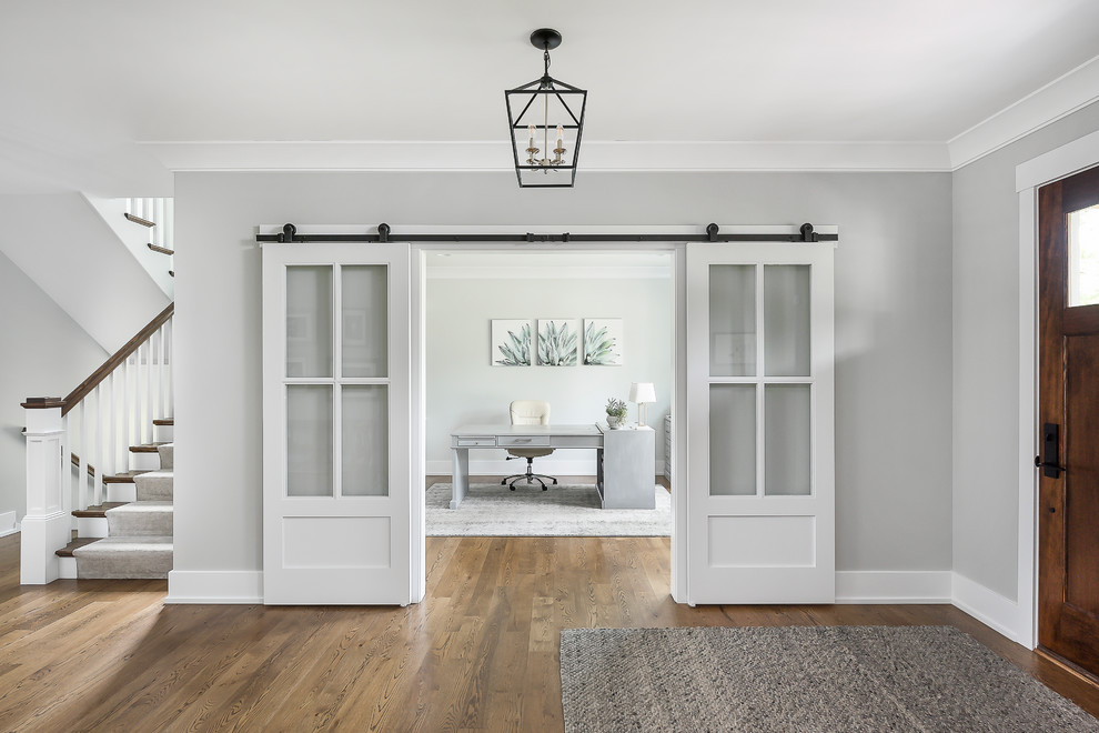Inspiration for a large transitional entry hall in Chicago with grey walls, a single front door, brown floor and dark hardwood floors.
