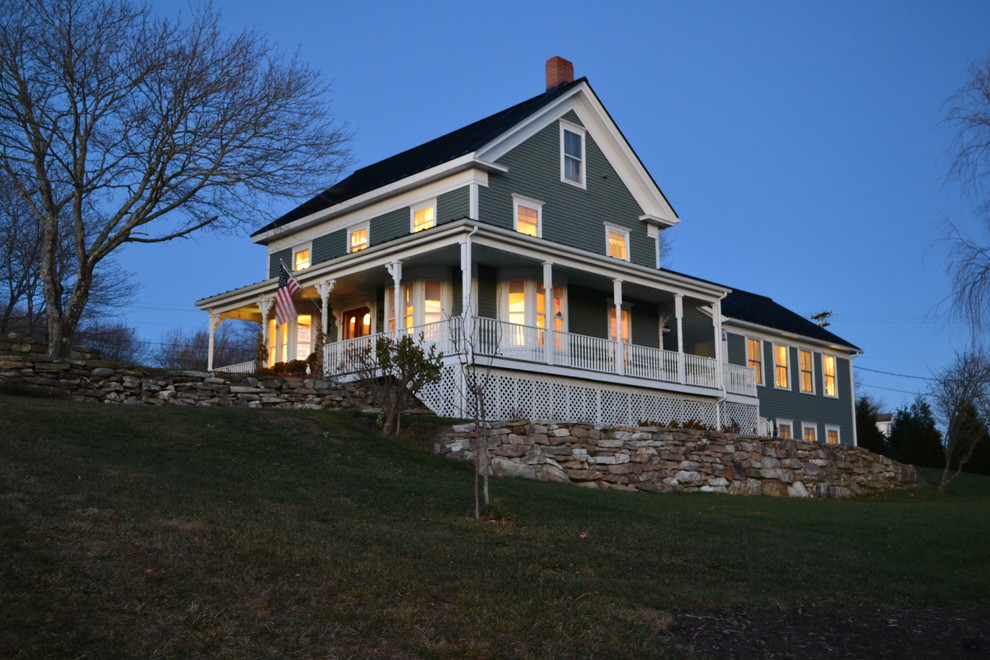 Large beach style two-storey green house exterior in Portland Maine with wood siding, a gable roof and a shingle roof.