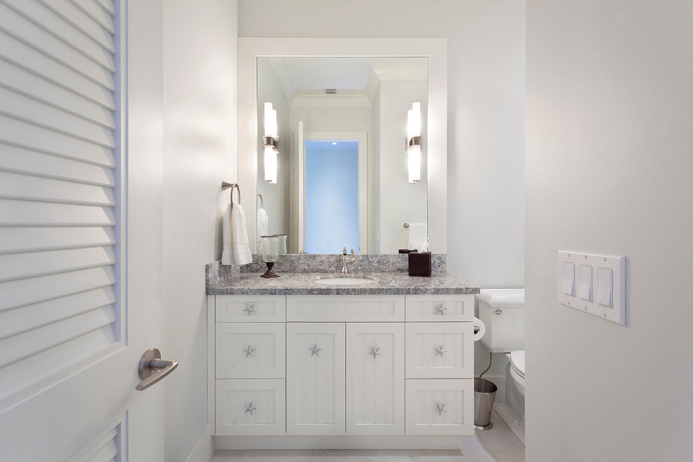 Bathroom - mid-sized transitional 3/4 porcelain tile and beige floor bathroom idea in Miami with recessed-panel cabinets, white cabinets, a one-piece toilet, white walls, an undermount sink, marble countertops and multicolored countertops
