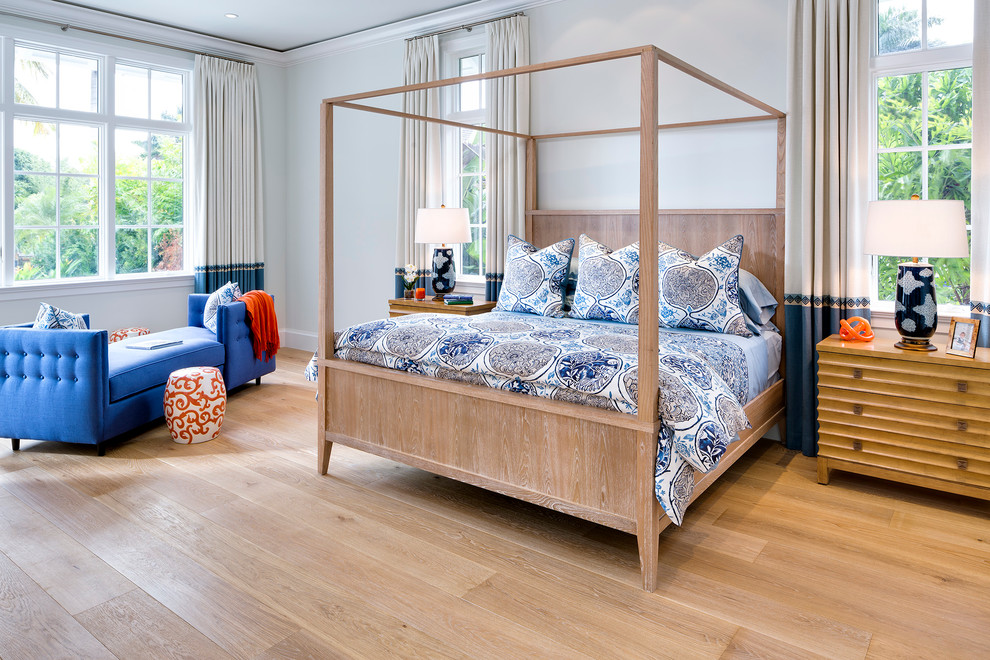 Large transitional master bedroom in Miami with light hardwood floors and white walls.