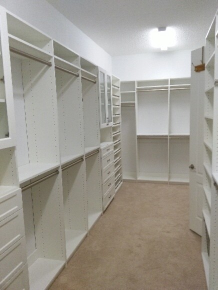 This is an example of a large traditional gender-neutral walk-in wardrobe in Jacksonville with white cabinets and carpet.