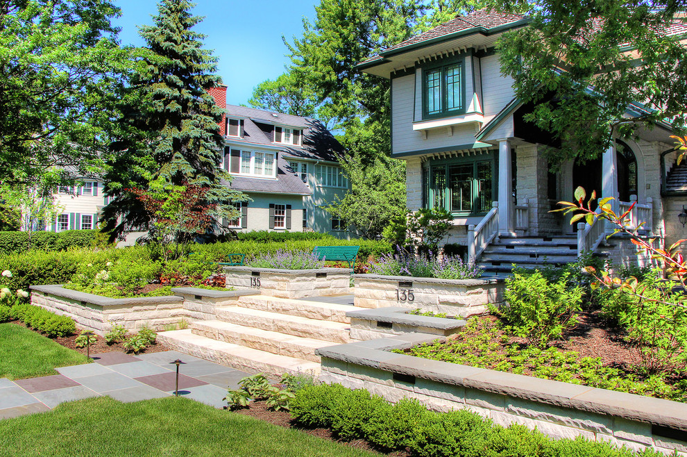 Inspiration for a mid-sized contemporary front yard patio in Chicago with natural stone pavers and a roof extension.
