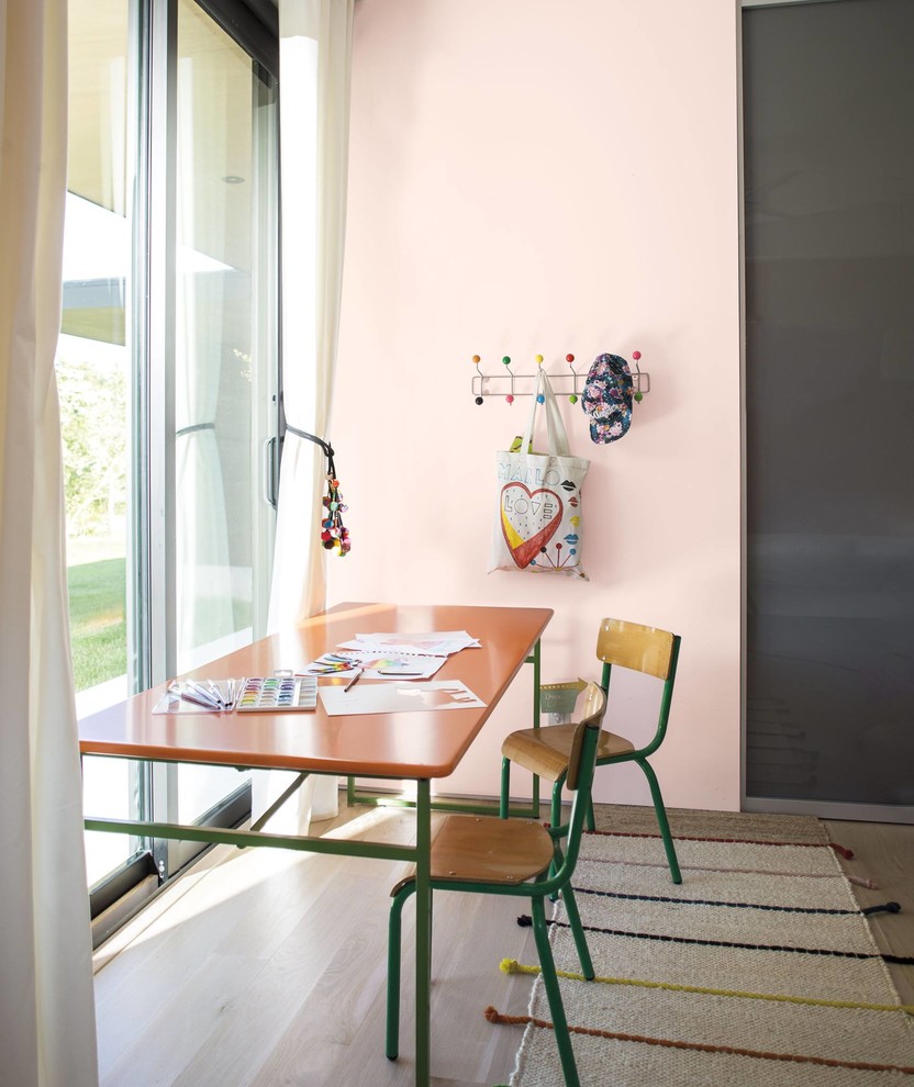 Design ideas for a contemporary gender-neutral kids' study room in Los Angeles with pink walls, light hardwood floors and beige floor.