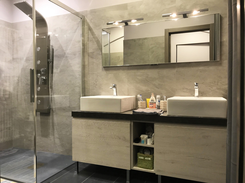 This is an example of a small modern 3/4 bathroom in Other with beaded inset cabinets, grey cabinets, a curbless shower, multi-coloured tile, porcelain tile, pink walls, slate floors, a vessel sink, quartzite benchtops, black floor, a hinged shower door and black benchtops.