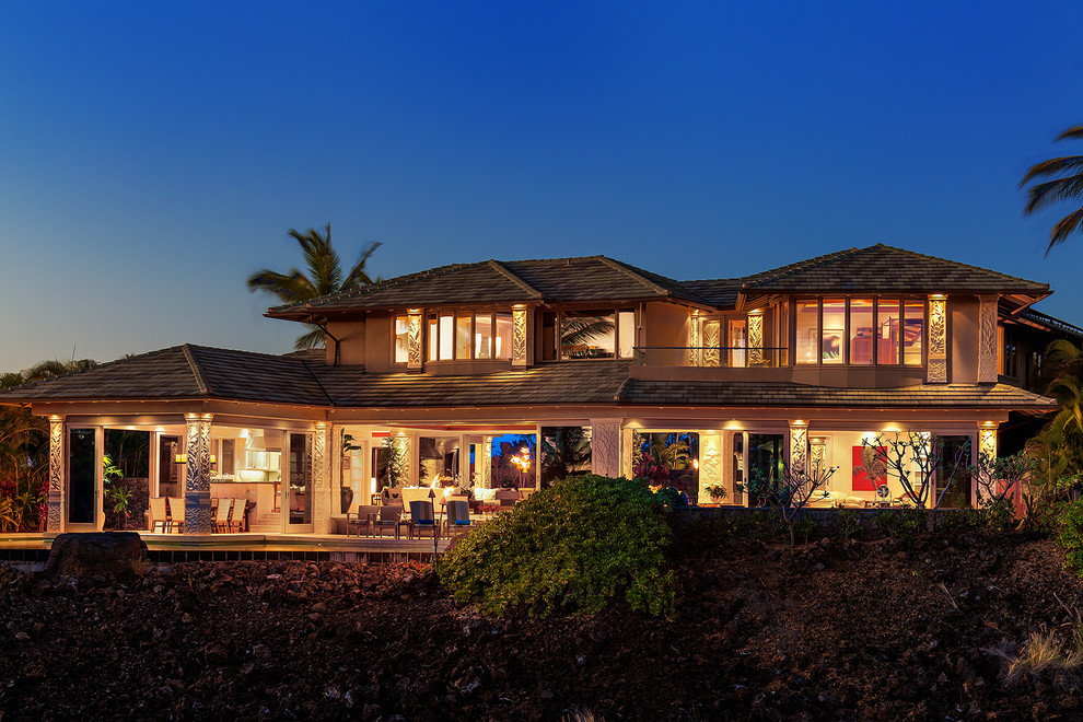 This is an example of an expansive tropical two-storey exterior in Hawaii with a hip roof.
