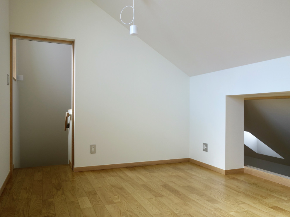 Immagine di una piccola cameretta per bambini design con pareti bianche, pavimento in compensato, pavimento marrone, soffitto a volta e carta da parati