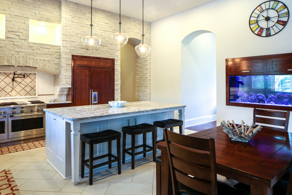 Mid-sized transitional l-shaped porcelain tile eat-in kitchen photo with an undermount sink, recessed-panel cabinets, dark wood cabinets, granite countertops, white backsplash, stainless steel appliances and an island