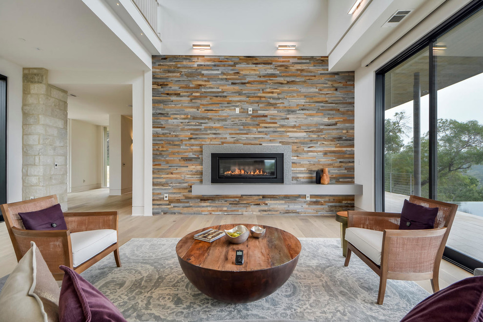 Contemporary living room in Austin with light hardwood floors and a ribbon fireplace.