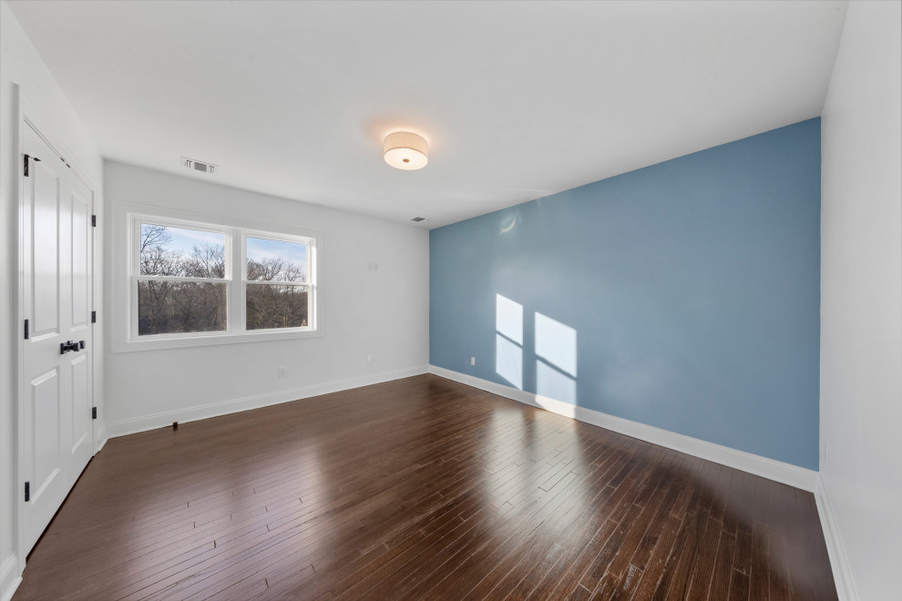 Bedroom with Blue Accent Wall and Dark Floors