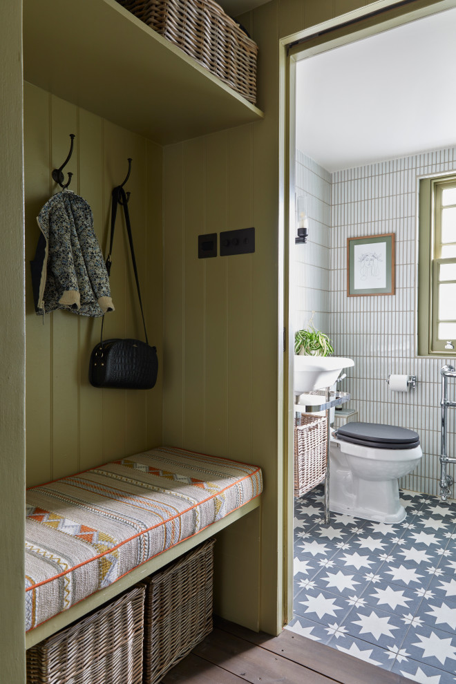 Exempel på ett litet klassiskt toalett, med öppna hyllor, en toalettstol med separat cisternkåpa, vit kakel, stickkakel, beige väggar, cementgolv, ett piedestal handfat och svart golv