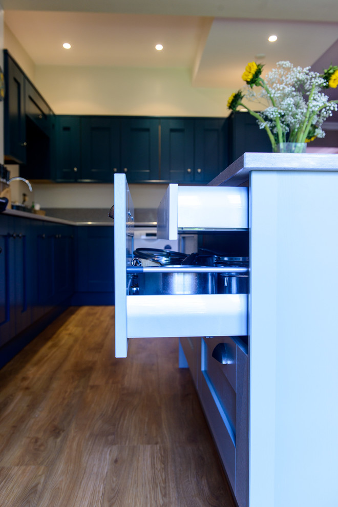 Inspiration for a transitional l-shaped eat-in kitchen in Kent with an undermount sink, shaker cabinets, blue cabinets, quartz benchtops, multi-coloured splashback, porcelain splashback and with island.
