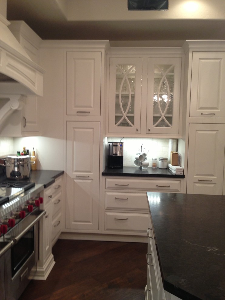 Kitchen - transitional dark wood floor kitchen idea in Phoenix with white cabinets, granite countertops, white backsplash, stainless steel appliances and an island