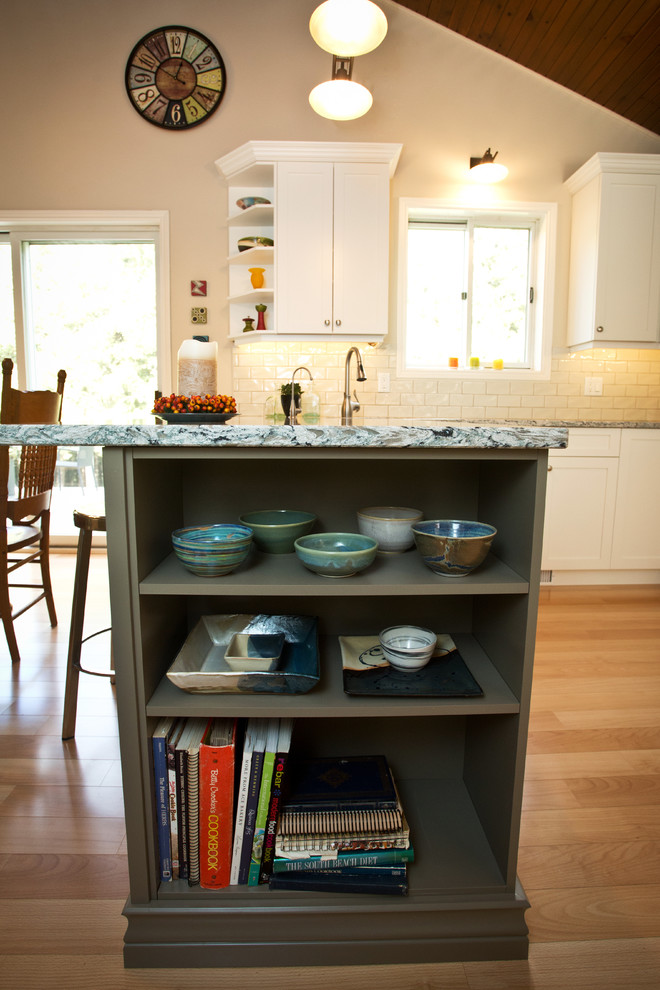 Example of a mid-sized transitional u-shaped light wood floor kitchen design in Toronto with an undermount sink, shaker cabinets, white cabinets, granite countertops, white backsplash, subway tile backsplash, white appliances and a peninsula