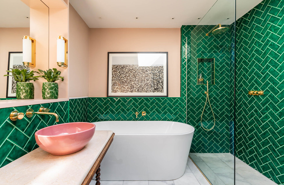 This is an example of a large eclectic master bathroom in London with dark wood cabinets, a freestanding tub, an open shower, green tile, ceramic tile, pink walls, marble floors, a vessel sink, marble benchtops, grey floor, an open shower and white benchtops.