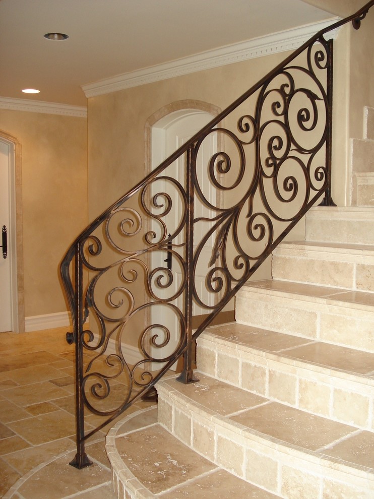 Photo of a small mediterranean tile straight staircase in Orange County with tile risers and metal railing.