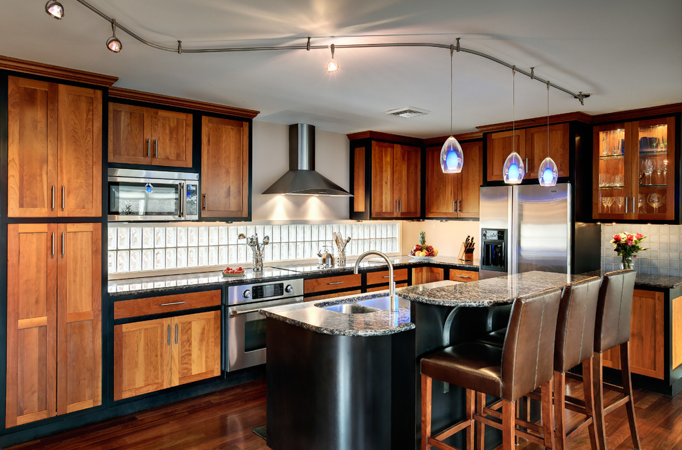 Photo of a mid-sized contemporary l-shaped open plan kitchen in Philadelphia with granite benchtops, a double-bowl sink, shaker cabinets, medium wood cabinets, white splashback, subway tile splashback, dark hardwood floors and with island.