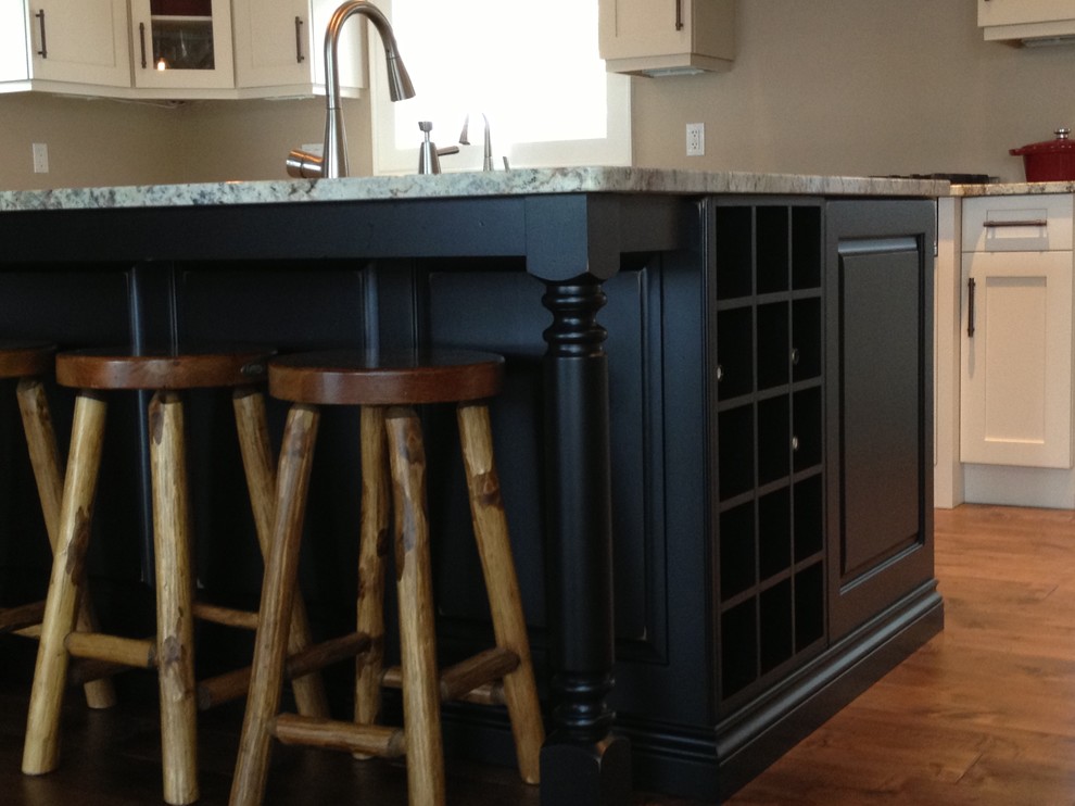 Inspiration for a mid-sized transitional l-shaped medium tone wood floor eat-in kitchen remodel in Toronto with a double-bowl sink, shaker cabinets, white cabinets, stainless steel appliances and an island