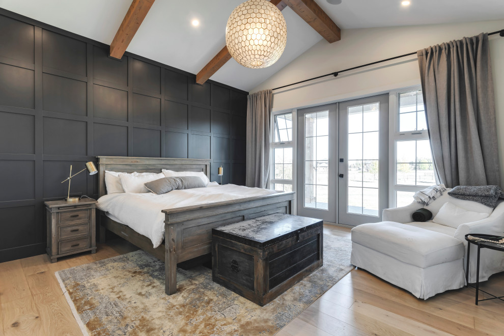 This is an example of a large transitional master bedroom in Calgary with white walls, brown floor, exposed beam, vaulted, panelled walls and light hardwood floors.