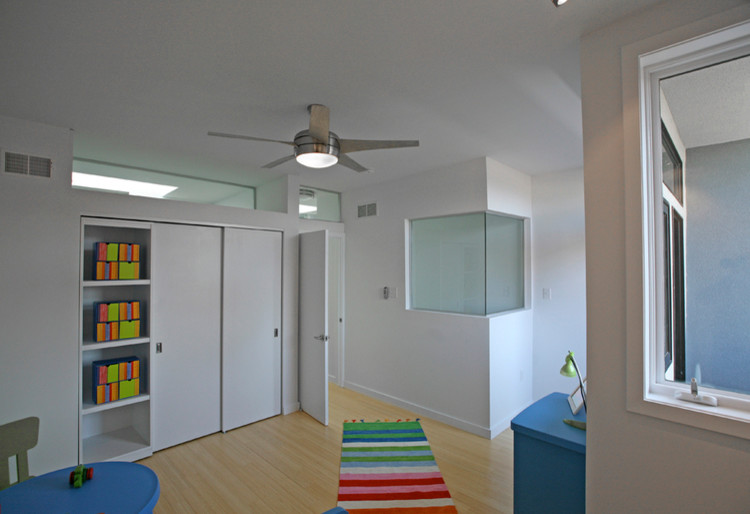 Contemporary gender-neutral kids' room in Philadelphia with white walls and bamboo floors.