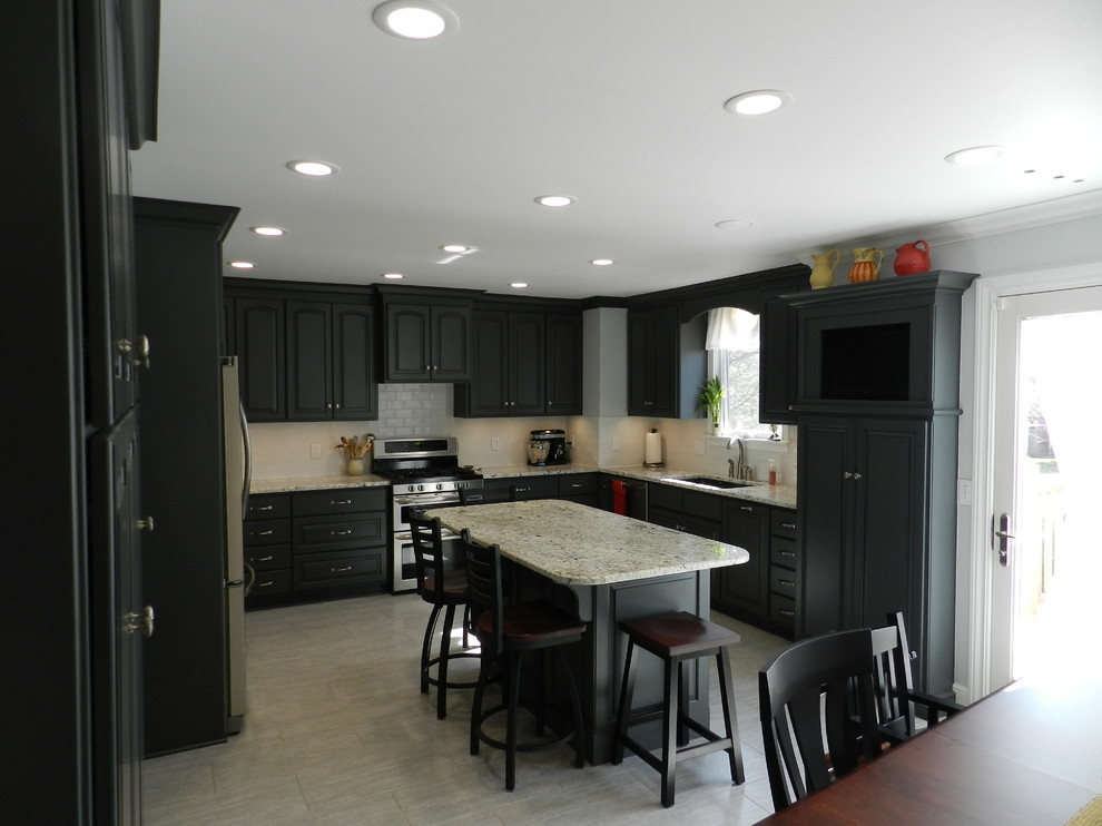 Enclosed kitchen - mid-sized transitional l-shaped porcelain tile and beige floor enclosed kitchen idea in Cleveland with an undermount sink, raised-panel cabinets, gray cabinets, granite countertops, white backsplash, subway tile backsplash, stainless steel appliances and an island