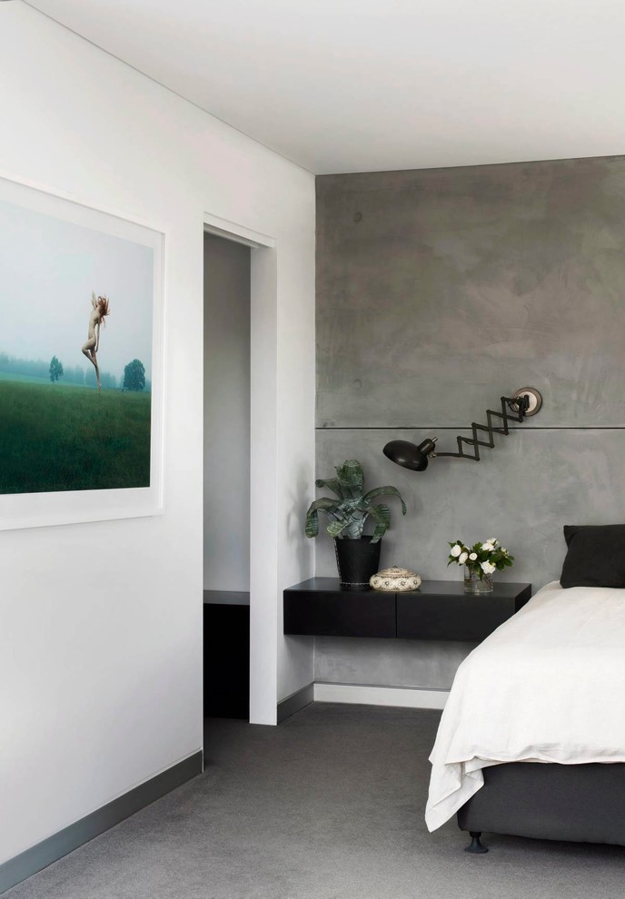 Mid-sized industrial guest bedroom in Sydney with grey walls, carpet, no fireplace and grey floor.