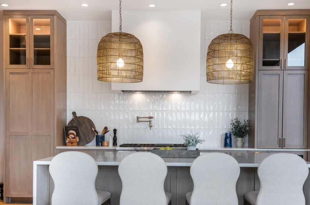 Inspiration for a large transitional l-shaped light wood floor and exposed beam open concept kitchen remodel with a farmhouse sink, shaker cabinets, medium tone wood cabinets, quartz countertops, white backsplash, subway tile backsplash, stainless steel appliances, an island and white countertops