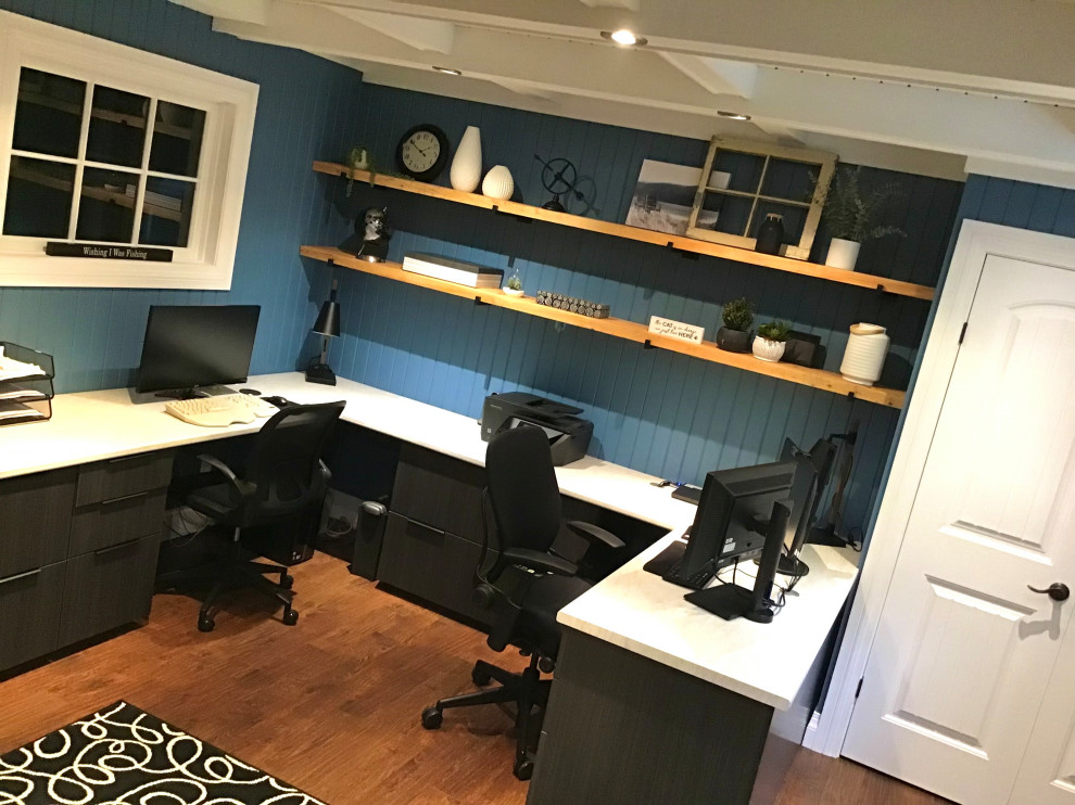 Modelo de despacho blanco campestre de tamaño medio con paredes azules, suelo laminado, escritorio empotrado, suelo marrón, casetón y madera