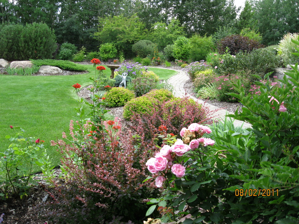 Inspiration for a large traditional backyard garden in Edmonton with a garden path and brick pavers.