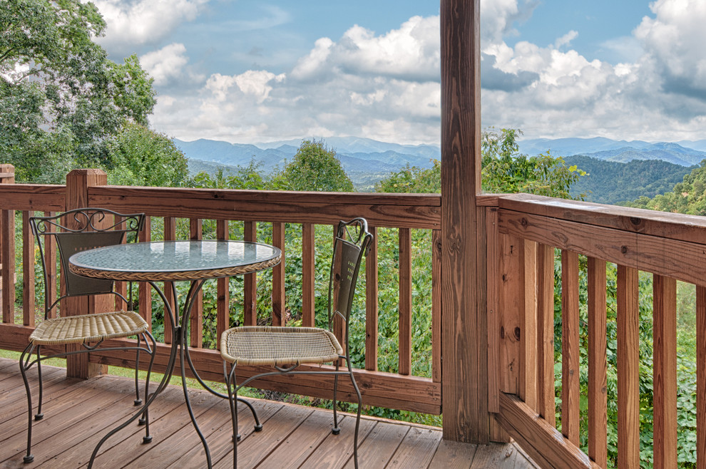 Example of a mid-sized mountain style backyard balcony deck design with a roof extension