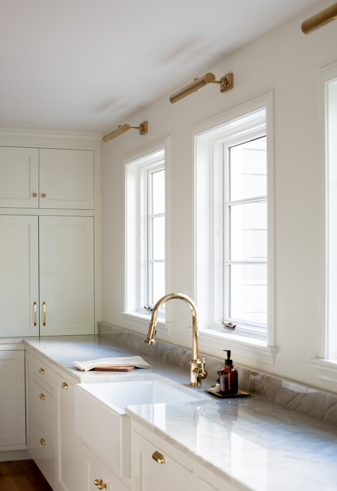 Exempel på ett stort klassiskt kök, med vita skåp, bänkskiva i kvartsit, vitt stänkskydd, stänkskydd i keramik, mellanmörkt trägolv, en köksö och brunt golv
