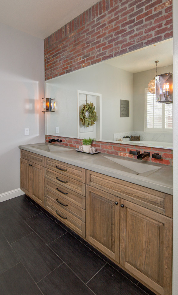This is an example of a large industrial master bathroom in Santa Barbara with flat-panel cabinets, medium wood cabinets, a drop-in tub, a corner shower, a two-piece toilet, white tile, porcelain tile, grey walls, porcelain floors, a trough sink and concrete benchtops.