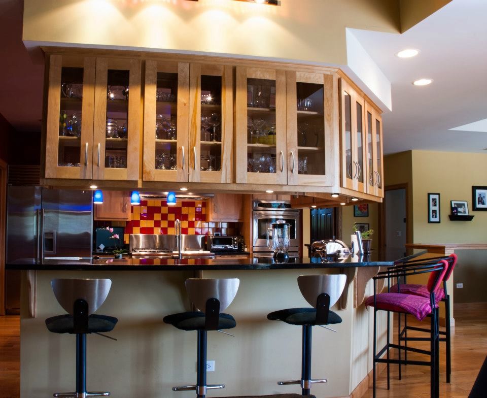 Kitchen - mid-sized transitional u-shaped medium tone wood floor and brown floor kitchen idea in Chicago with a farmhouse sink, glass-front cabinets, light wood cabinets, quartzite countertops, multicolored backsplash, ceramic backsplash, stainless steel appliances and an island