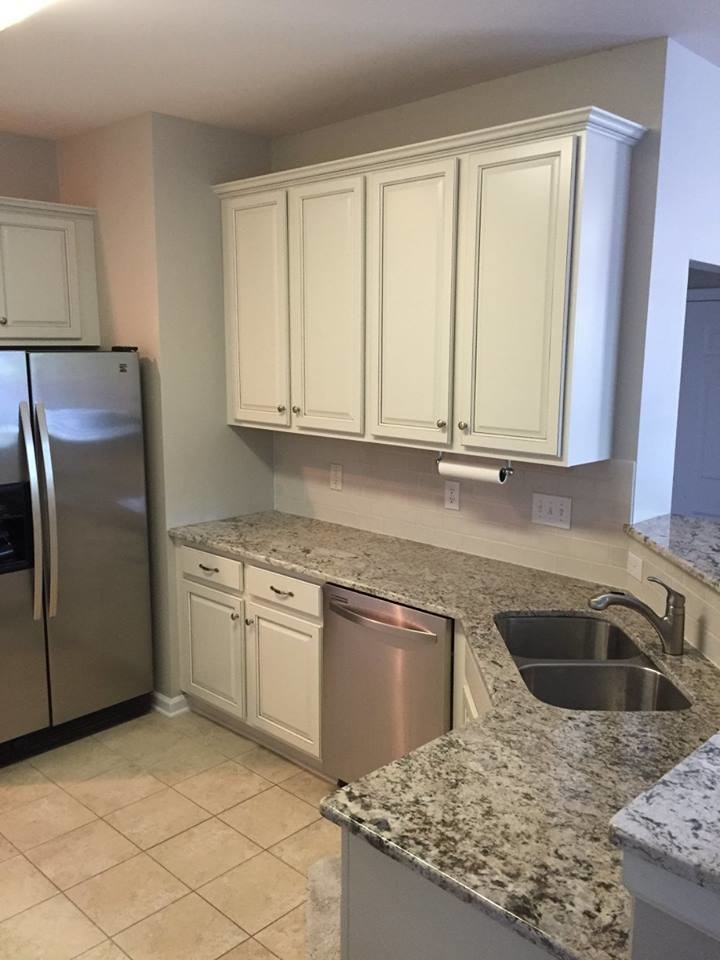 Inspiration for a mid-sized transitional u-shaped ceramic tile home design remodel in Charlotte with an undermount sink, raised-panel cabinets, white cabinets, granite countertops, white backsplash, subway tile backsplash, stainless steel appliances and no island