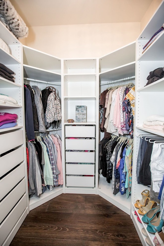 This is an example of a small traditional gender-neutral walk-in wardrobe in Other with open cabinets, white cabinets, dark hardwood floors and brown floor.
