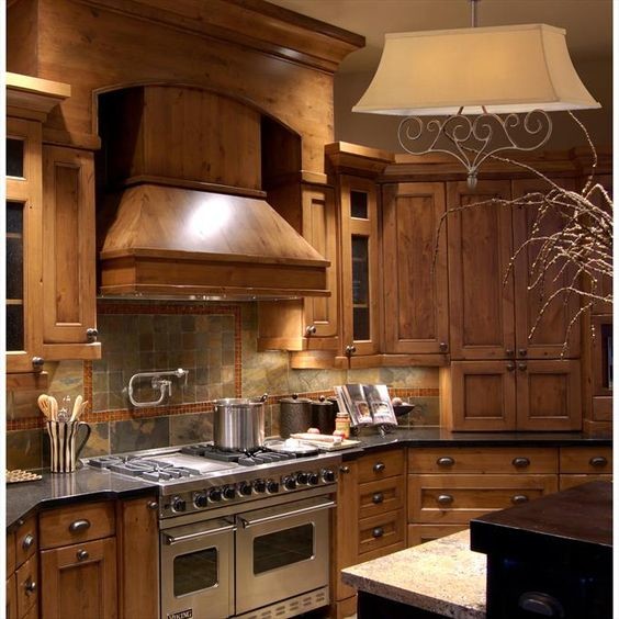 Example of a mid-sized mountain style u-shaped kitchen design in New York with shaker cabinets, medium tone wood cabinets, quartzite countertops, multicolored backsplash, stone tile backsplash, stainless steel appliances and an island