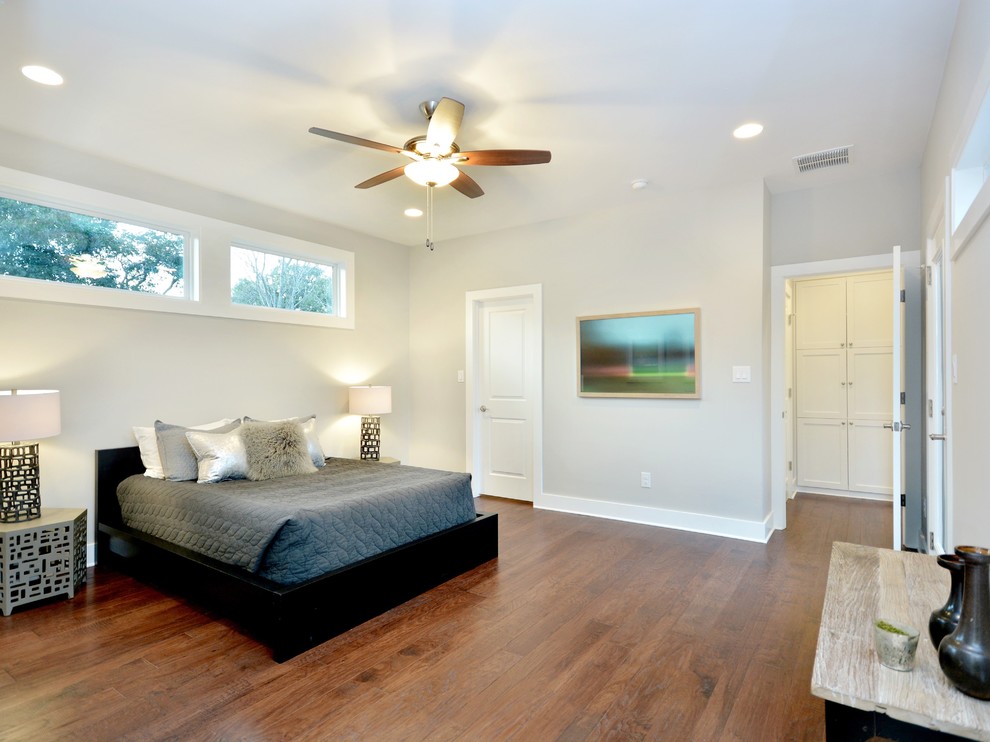 Inspiration for a large arts and crafts master bedroom in Austin with grey walls and medium hardwood floors.