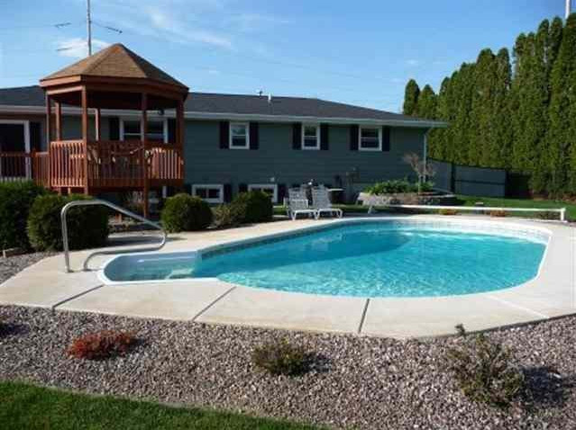 Backyard concrete and custom-shaped pool photo