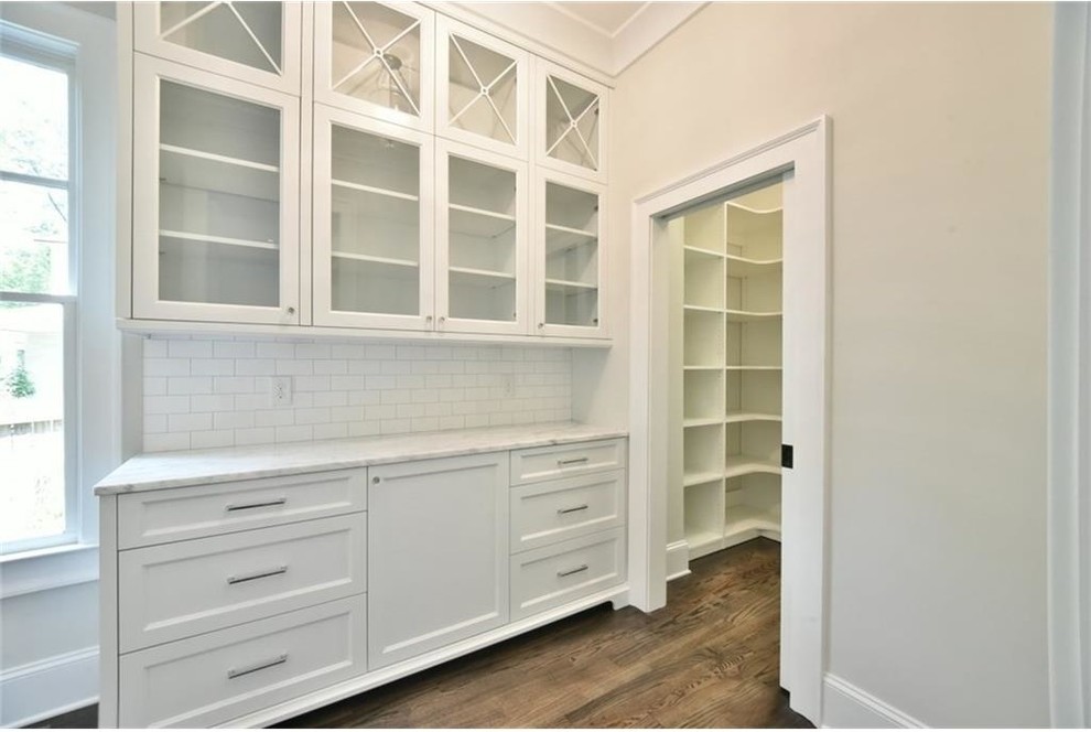 Inspiration for a transitional dark wood floor kitchen remodel in Atlanta with shaker cabinets, white cabinets, marble countertops, white backsplash, subway tile backsplash and stainless steel appliances