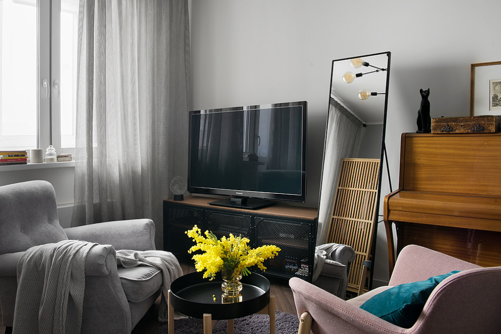 Идея дизайна: серо-белая гостиная комната среднего размера в современном стиле с музыкальной комнатой, серыми стенами, полом из ламината, отдельно стоящим телевизором, зоной отдыха, коричневым полом и акцентной стеной