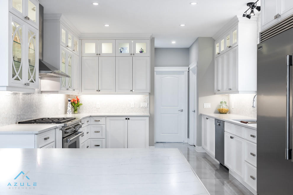 Large transitional u-shaped porcelain tile enclosed kitchen photo with recessed-panel cabinets, white cabinets, quartz countertops, white backsplash, marble backsplash, stainless steel appliances, an island and white countertops