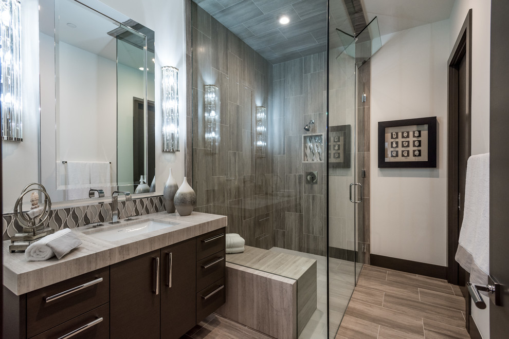 This is an example of a mid-sized contemporary 3/4 bathroom in Las Vegas with flat-panel cabinets, brown cabinets, a corner shower, brown tile, porcelain tile, white walls, porcelain floors, an undermount sink, engineered quartz benchtops, brown floor, a hinged shower door and grey benchtops.